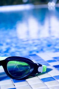 Glasses for diving on the edge of a summer pool. No people