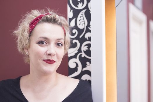Portrait of blonde woman with short hair and pinup style. Relaxed expression