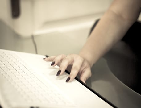 Womans hand on white computer keyboard. Copy space