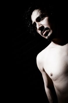 Portrait of latin man with beard and curly black hair. Naked torso