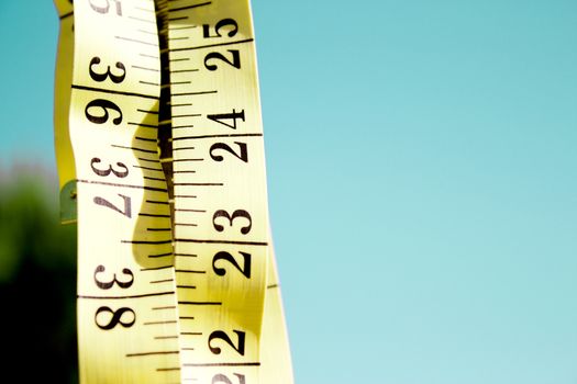 Measuring tape on blue background. No people