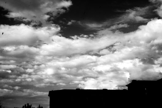 Sky in black and white with part of building. Dark scene and feeling sad