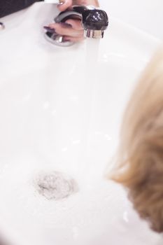 Hairdresser washing the head of a client. Hair not yet wet