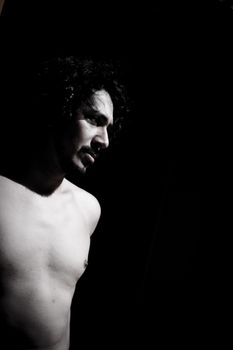 Portrait of latin man with beard and curly black hair. Naked torso