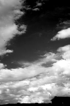 Sky in black and white with part of building. Dark scene and feeling sad