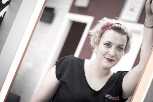 Portrait of blonde woman with short hair and pinup style. Relaxed expression