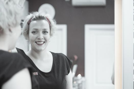 Portrait of blonde woman with short hair and pinup style. Relaxed expression