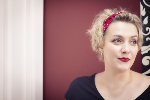 Portrait of blonde woman with short hair and pinup style. Relaxed expression