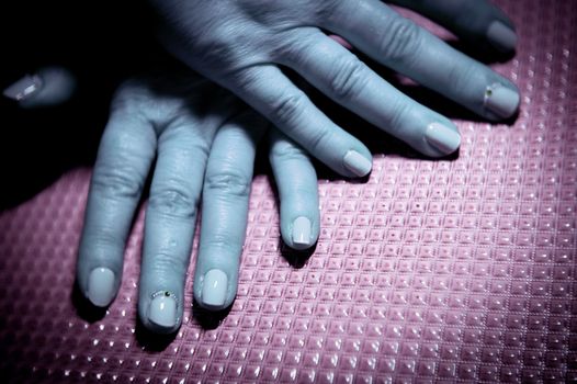 Womans hands showing semi-permanent beige manicure