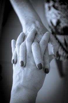 Hands of old woman and elderly caregiver