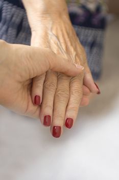 Hands of old woman and elderly caregiver