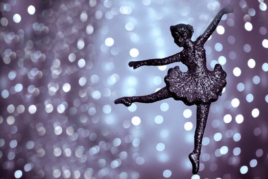 Silhouette of ballet dancer on bright bokeh background