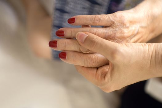 Hands of old woman and elderly caregiver