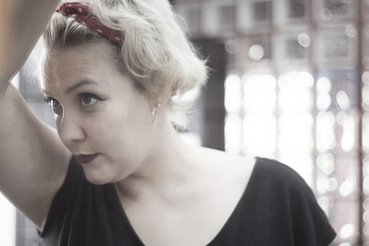 Portrait of blonde woman with short hair and pinup style. Relaxed expression