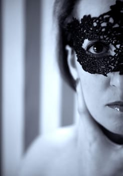 Elegant dressed woman hiding her face by a mask