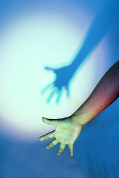 Extended arm with shadow in color, feeling of loneliness
