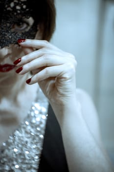 Elegant dressed woman hiding her face by a mask