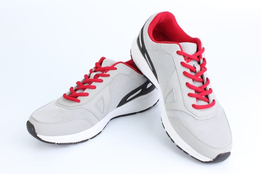 Gray sneakers with red laces on a white background