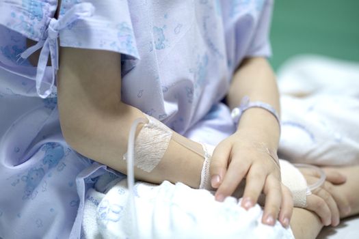 Sick child on a receiving a saline solution in hospital