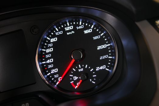 an analogue speedometer on a board with instruments in a passenger car