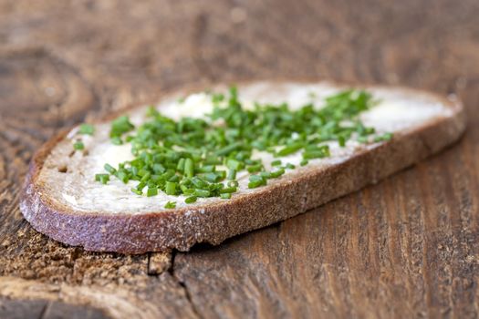 bread with butter and chives on wood