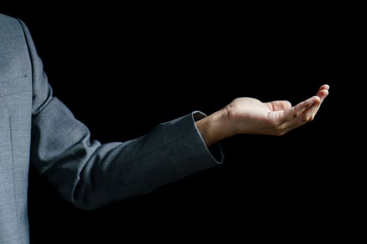 Business man open empty hand on black background.