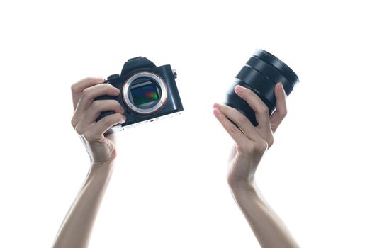 Woman hand holding camera and lens on white background.