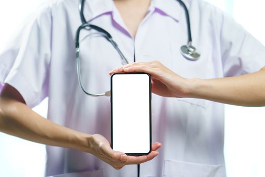 Doctor in uniform holding smart phone with blank white screen for text. Coronavirus, covid-19 outbreak concept. isolated on white background.