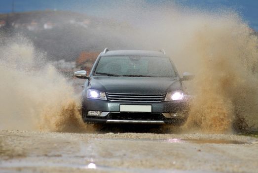 Car drives through flooded road