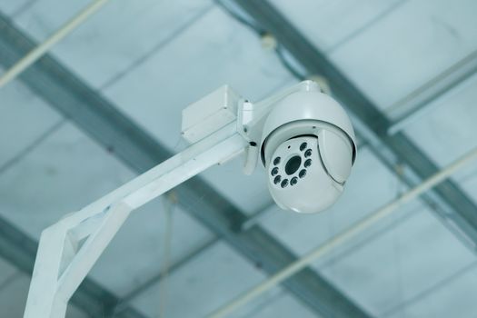 CCTV camera on a wall background. Concept of surveillance and safety.