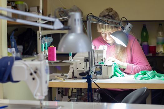 garment worker at the work desk by the light of the lamp