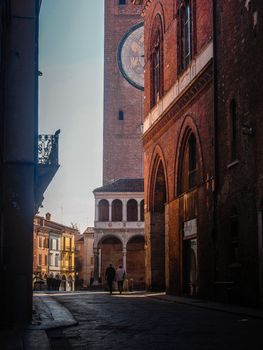 Cremona, Lombardy, Italy - May  5 6 7  2020 - man or woman walking or biking in deserted downtown  during covid outbreak lockdown phase 2