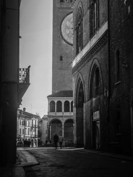 Cremona, Lombardy, Italy - May  5 6 7  2020 - man or woman walking or biking in deserted downtown  during covid outbreak lockdown phase 2