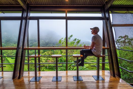 Bijagua de Upala, Costa Rica - January 17, 2020 : Tourist sitting in the lounge bar of Celeste Mountain Lodge, a three-star lodge bordering the Tenorio Volcano National Park and the Rio Celeste.