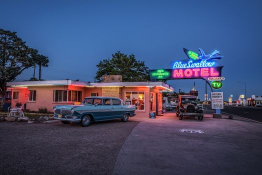 TUCUMCARI, NEW MEXICO - MAY 13, 2016 : Historic Blue Swallow Motel with vintage cars parked in front of it. This building is listed on the National Register of Historic Places in New Mexico.