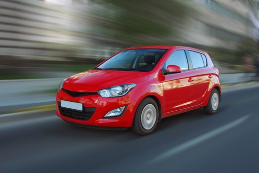 A panning shot of a speeding red car