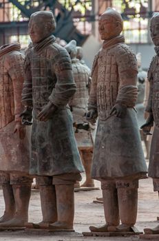 Xian, China - May 1, 2010: Terracotta Army museum and hall.  Full body closeup of gray-beige sculptures of soldiers at excavation.