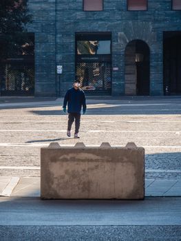 Cremona, Lombardy, Italy - May  5 6 7  2020 - man or woman walking or biking in deserted downtown  during covid outbreak lockdown phase 2