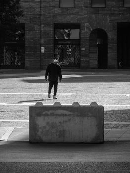 Cremona, Lombardy, Italy - May  5 6 7  2020 - man or woman walking or biking in deserted downtown  during covid outbreak lockdown phase 2