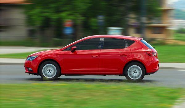 A panning shot of a speeding red car