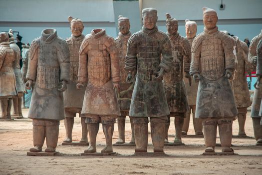 Xian, China - May 1, 2010: Terracotta Army museum and hall.  Frontal view on gray-beige sculptures of group of soldiers, some decapitated at excavation.