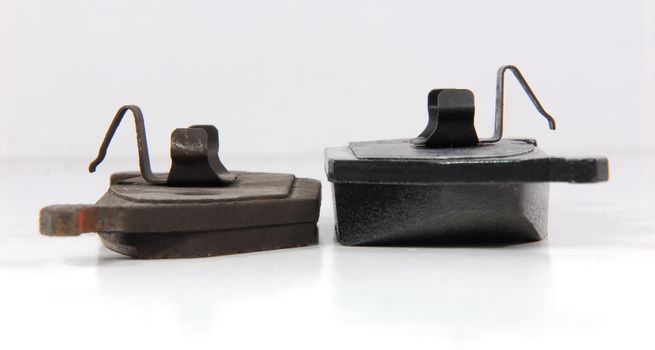 one new and one old brake pad for car