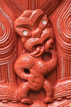 Laie, Oahu, Hawaii, USA. - January 09, 2020: Polynesian Cultural Center. Closeup of detail of red wooden sculpture showing small scary figure at New Zealand Maori hawaikiroa hall.