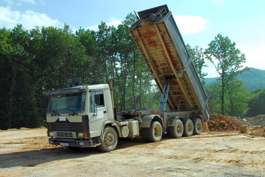 big tipper truck unloading land on the site