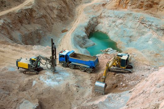 Yellow excavator loading stones in a truck