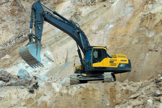 big yellow loader carries a large stone in the quarry