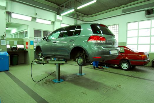 Car on base plate of lift in workshop