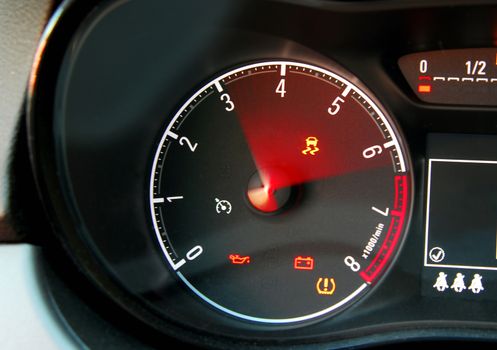 Tachometer reaching the red zone, sports car inside