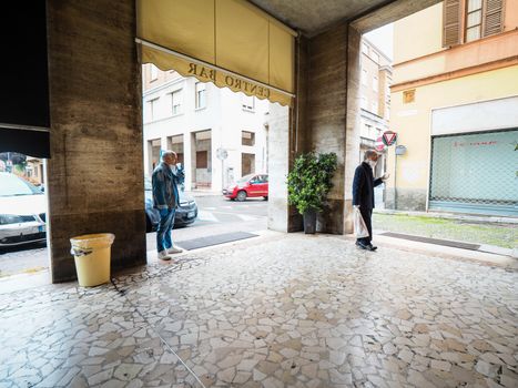 Cremona, Lombardy Italy,  may 2020 -  Bartender woman  at cafe bar in city center slowly open and make drinks only to go and some usual customers return  - new stage of coronavirus outbreak