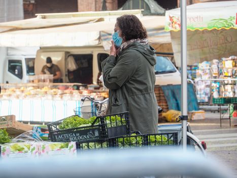 Cremona, Lombardy, Italy - 16 th may 2020 - People grocery shopping socially distance d in local biologic open air  food market wearing protection facial mask to prevent against contagion of coronavirus infection disease